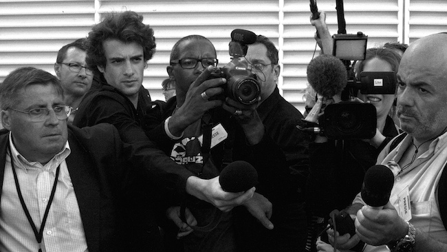 group of reporters with cameras and microphones eager to interview a source