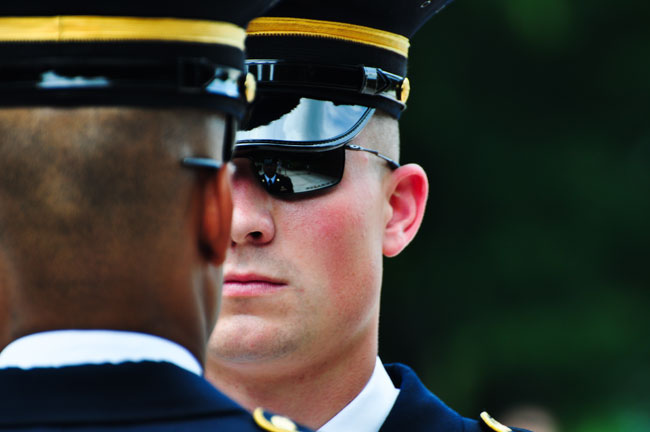 Sgt. Benton Thames inspects a sentinel before the sentinel begins his walk on the mat at Arlington National Cemetery.
